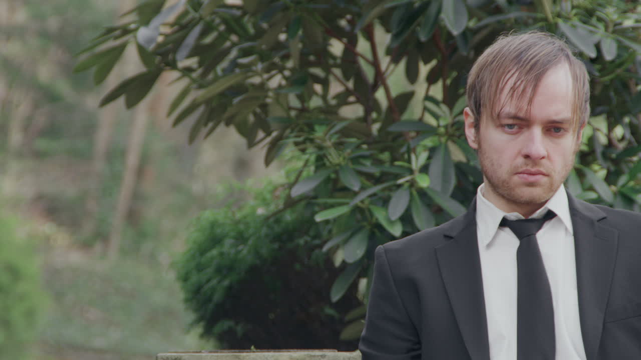 벤치에 앉아 있는 슬픈 남자, 중간 클로즈업