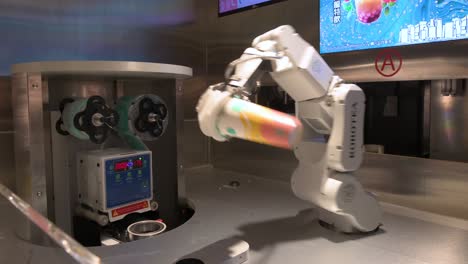 un brazo robótico automatizado prepara una bebida para un cliente combinando elementos de ingeniería, matemáticas y tecnología de inteligencia artificial en una tienda de té de un centro comercial en hong kong