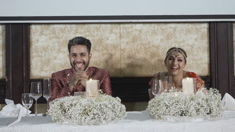 newlywed indian couple on their wedding reception table