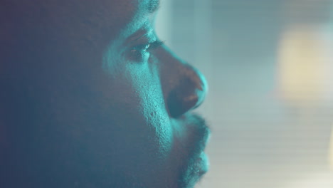 close up of pensive african american man looking through window