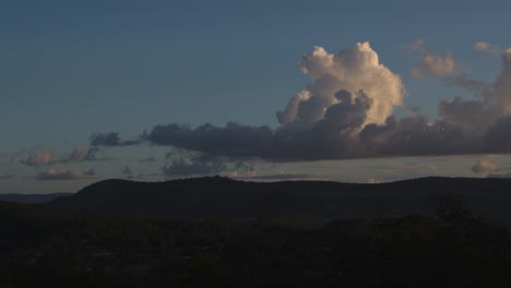 nubes moviéndose sobre un paisaje montañoso al anochecer.