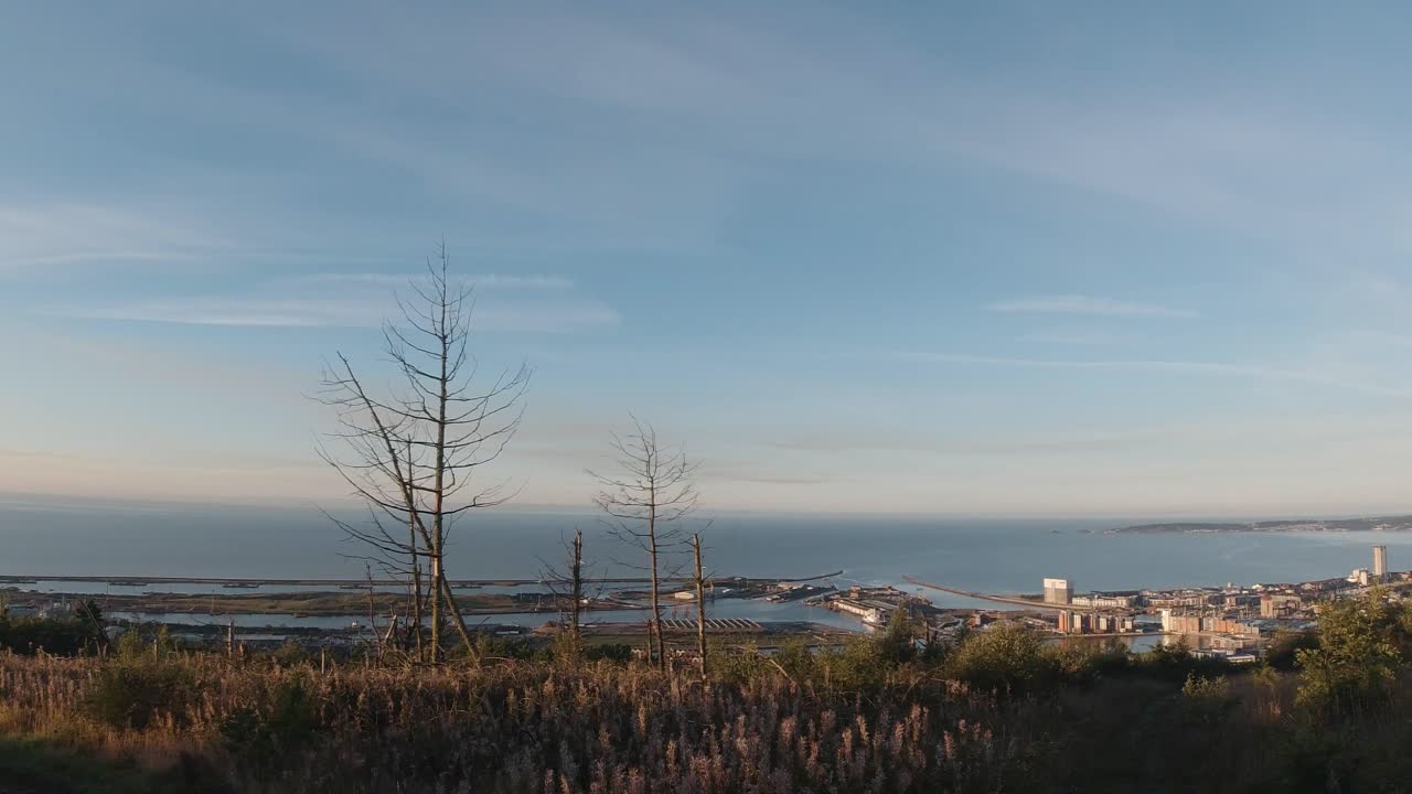 언덕 꼭대기에서 바다와 마리나를 가로질러 해가 뜨는 판