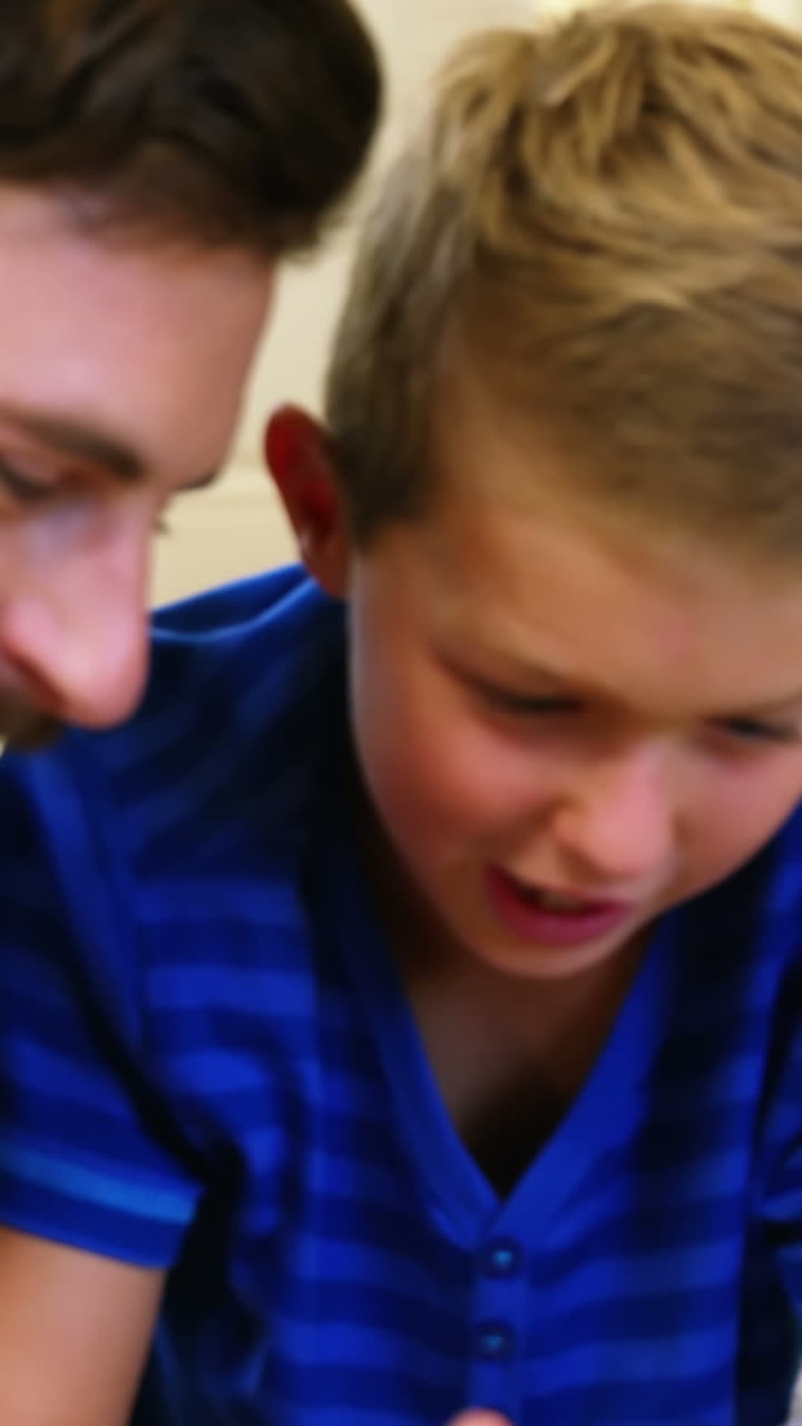 아버지 와 아들 이 디지털 태블릿 을 사용 하고 있다