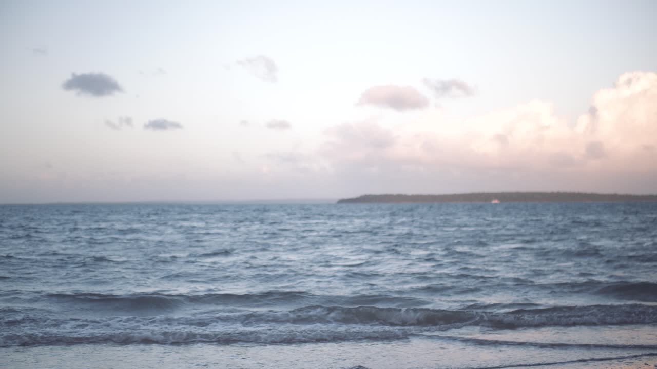 해가 지면 바가에 물이 부드럽게 흘러들어오는데, 해가 물러나면 파스텔색의 분홍색과 파란색이 하늘과 은 구름에 어지고, 멀리서 섬과 배가 앉아 있다.