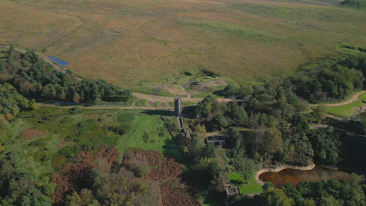 одинокая каменная башня, построенная на склоне холма, дальний вид с вращением и подъемом, раскрывающий структуру холма за его пределами