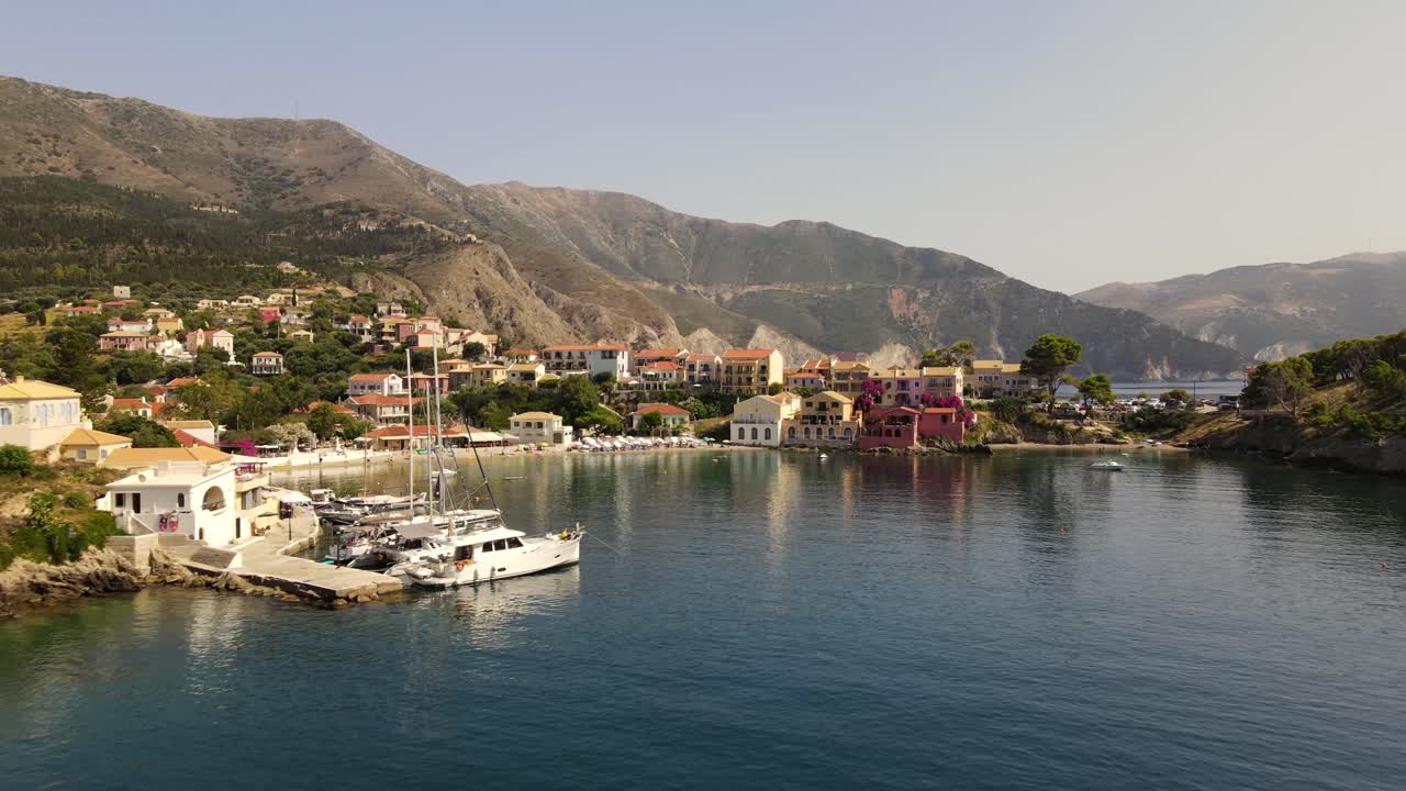 Famous colorful houses on beach Asos in Kefalonia, Greece, aerial sunset dolly