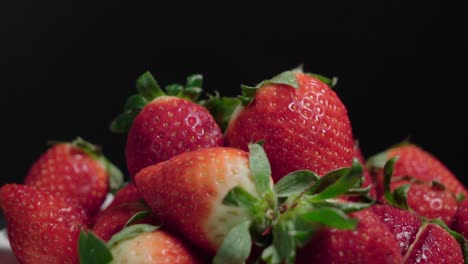 juicy strawberries isolated on black background, closeup pan left