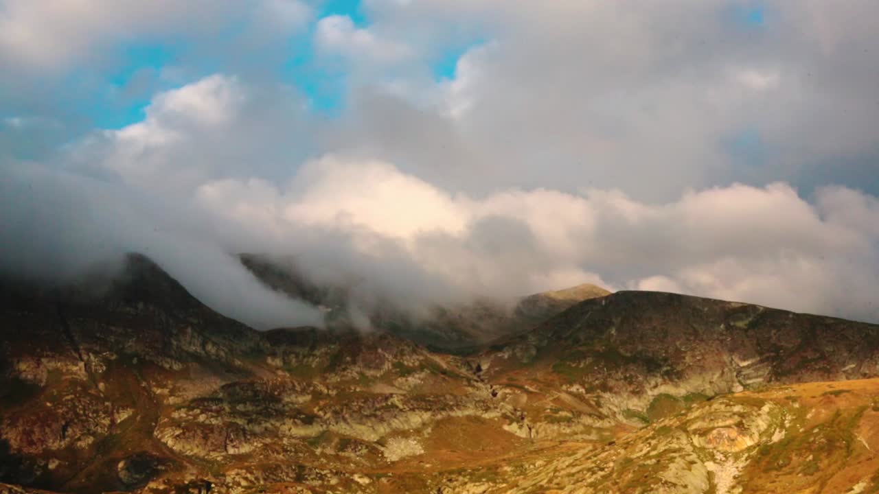 View of the Rila mountains with low clouds passing through
