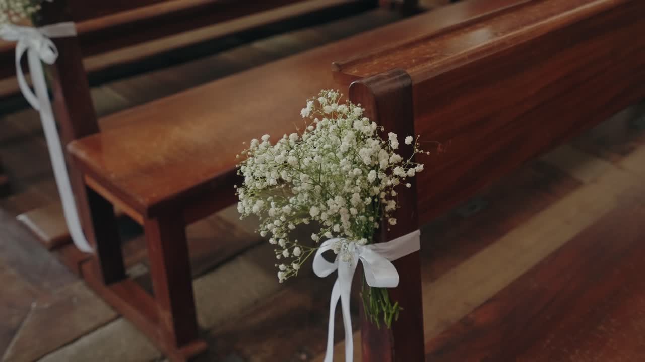 Delicate baby’s breath decor tied with ribbon on church pew