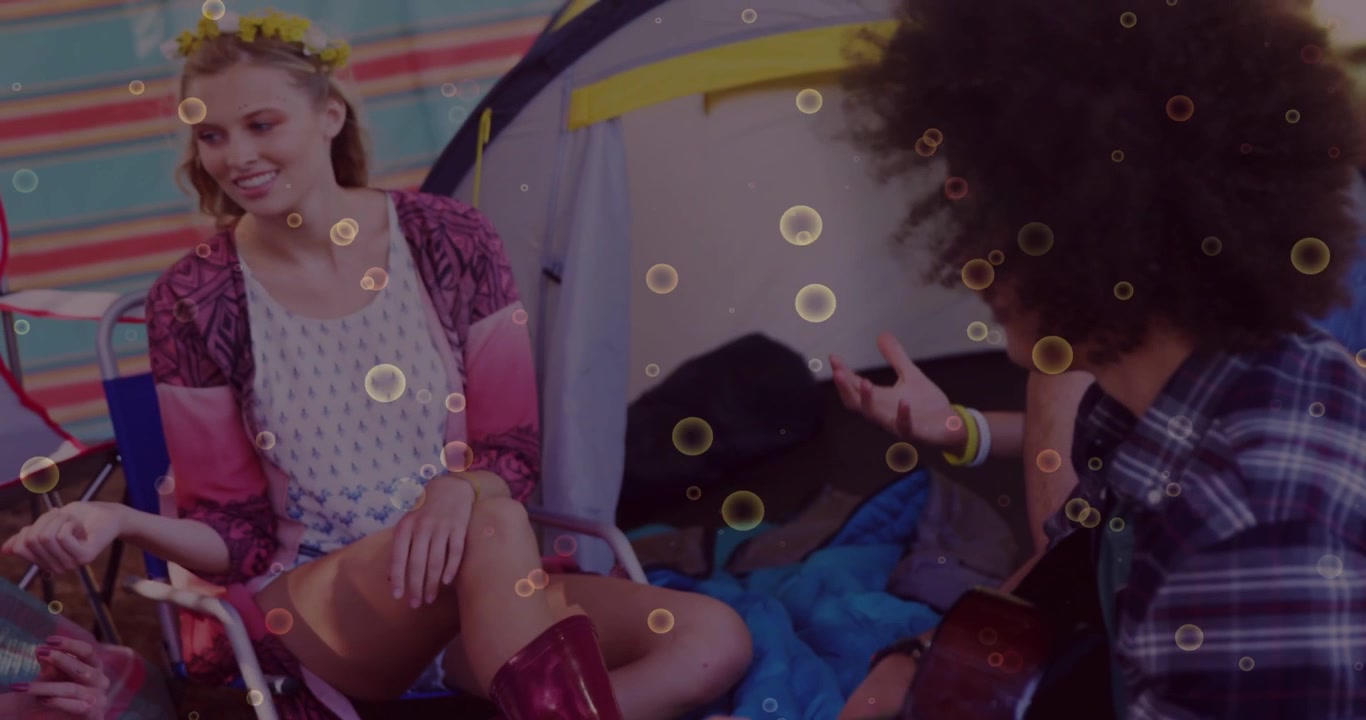 Vertical video: Guitarist strumming sparking cam pan showing tent, music, woman gesturing bokeh