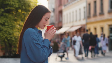 joyful woman enjoying drinking morning aroma coffee hot drink relaxing taking a break in city street