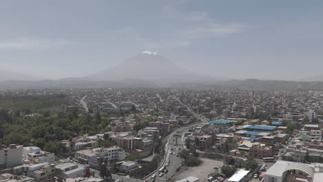 backwards moving drone shot above arequipa peru on a bright day with some mist with view on the mountain log