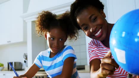 Mother-assisting-daughter-in-homework