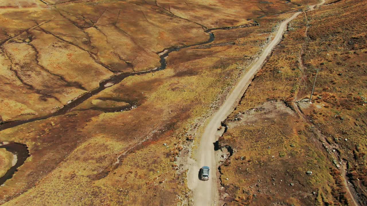 Vehicle exploring the remote road of Lares trek, Peru, near Quechua indigenous community of Chaullacocha. Aerial dolly in