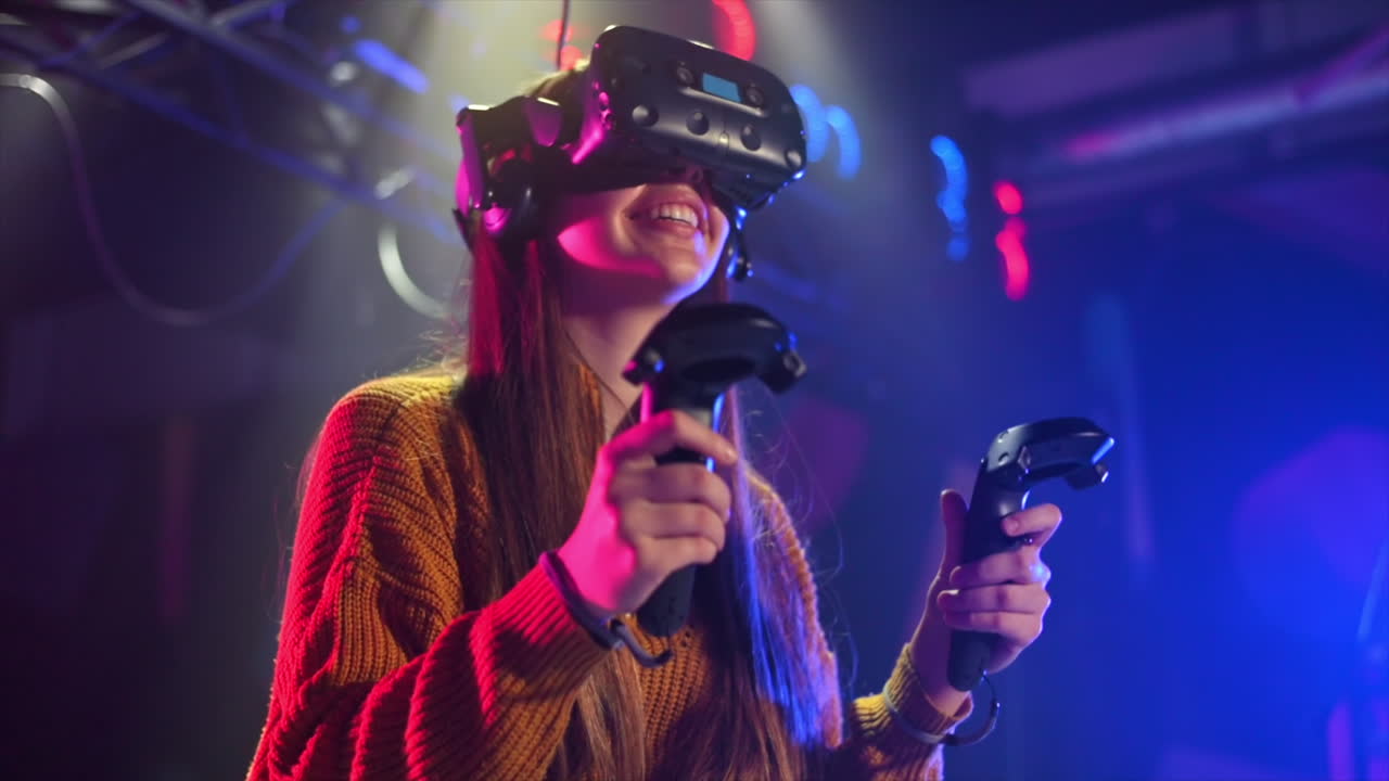 Una ragazza allegra e interessata sta vincendo su un tapis roulant VR con casco e controller. Rallentatore