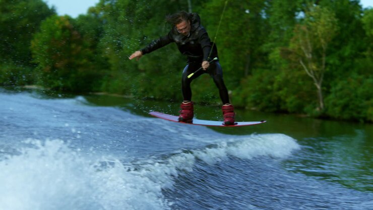 Man riding board on waves of river