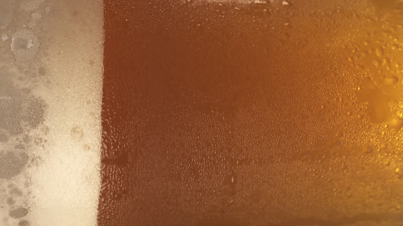 toma vertical de la plataforma giratoria de cerveza fría giratoria en vidrio sudoroso