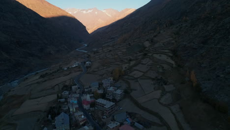 establishing drone shot of a peaceful mountain village during autumn season