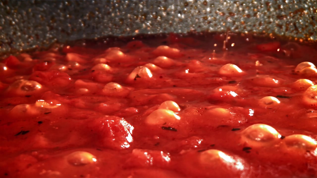 Deliziosa salsa di pomodoro rossa che bolle e ribolle in una padella