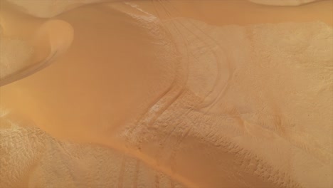 aerial drone flight over intricate patterns and textures of wind-sculpted sand dunes in el agunia desert, morocco. copy space