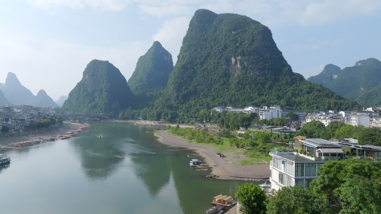 Stigende luftfoto langs Li-floden, mod karsttoppe, i solrige Yangshuo, Kina