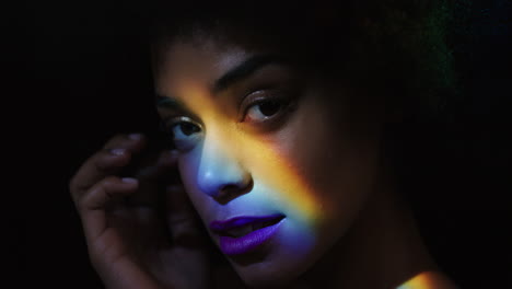 close up rainbow portrait attractive african american woman with afro enjoying smooth healthy skin complexion looking confident natural beauty multicolor light on black background skincare concept