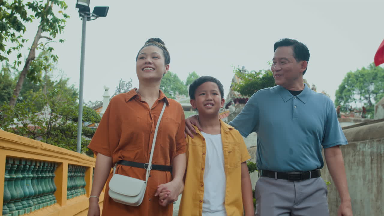 Son and Spouses Walking and Talking on Temple Territory
