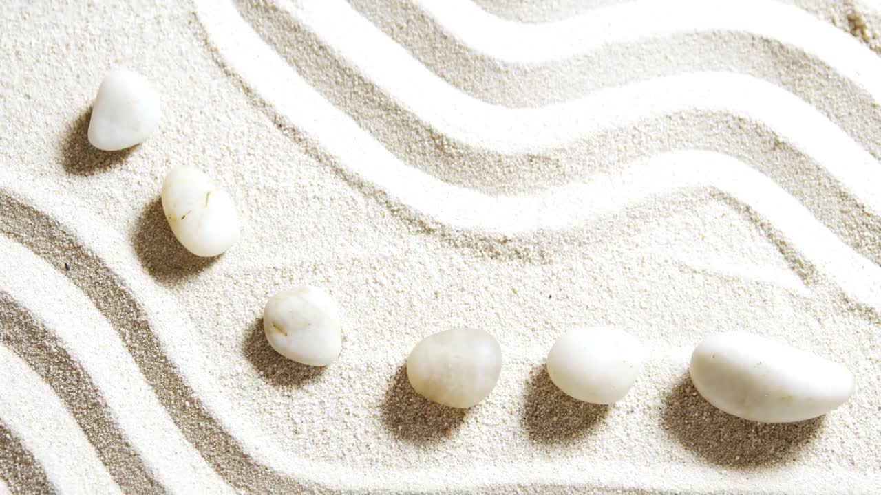 모래 위 에 배열 된 여러 가지 자갈 돌