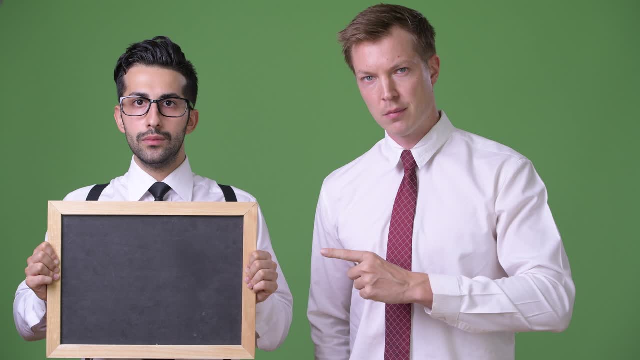 초록색 배경에서 함께 일하는 두 명의 젊은 다민족 사업가