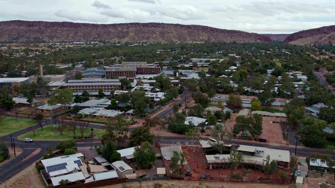 Rising drone footage of Alice Springs, looking south towards the MacDonnell Ranges and Heavitree Gap, Alice Springs, Mparntwe, Northern Territory, Australia. August 2022.