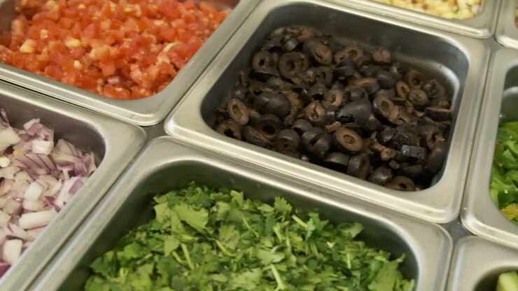 Panoramica di una cucina commerciale con guarnizioni di ingredienti freschi.