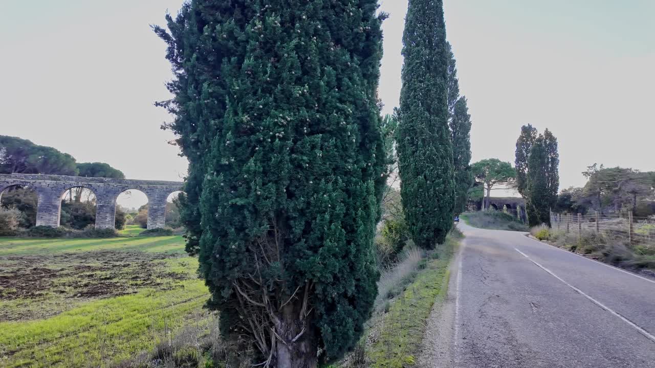Aqueduc en pierre près de Tomar, Portugal, montrant de longues arches traversant des champs ouverts avec des arbres et une lumière du jour claire dans un paysage rural, vue panoramique à main levée.