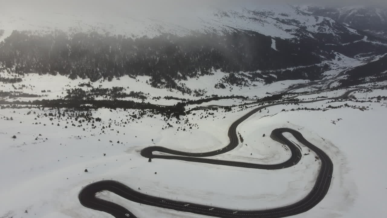 Cold white snowy mountain travel landscape twisty road in Andorra, aerial view