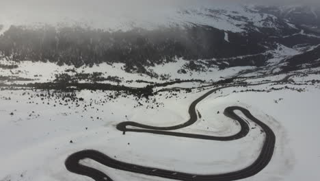 cold white snowy mountain travel landscape twisty road in andorra, aerial view