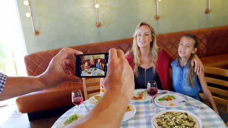 man taking photo of his family with mobile phone 4k