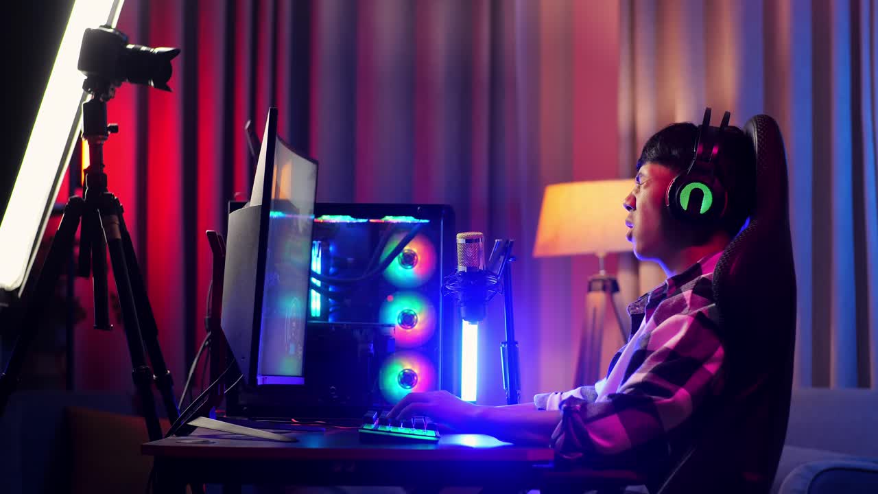 vista lateral del chico asiático streamer sintiéndose decepcionado falla el juego en la computadora personal. videojuego de transmisión en vivo, escritorio iluminado por luz de tira led rgb