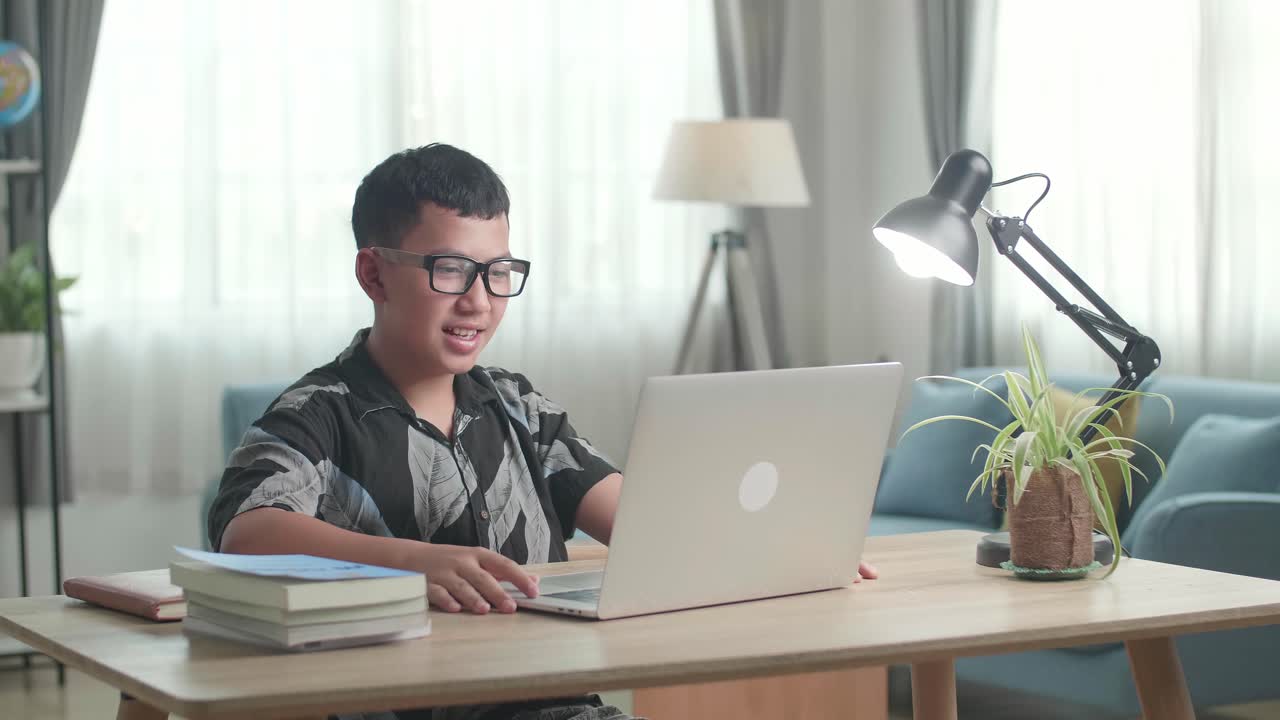 Teenage Boy Learning Online From Laptop, Raising Hand Distance Learning Online At Virtual Lesson Class With Teacher Tutor On Laptop By Video Conference Call At Home
