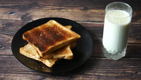 un vaso de leche y pan tostado en la mesa ,