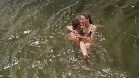 Caucasian-couple-having-a-good-time-on-a-trip-to-the-mountains,-wearing-bathing-suits-and-standing-i