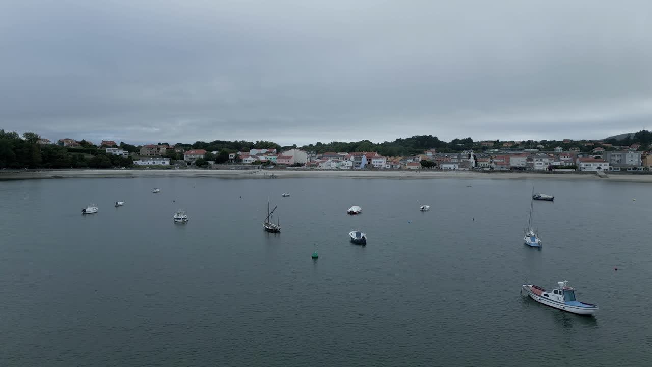 avión volando sobre barcos en la costa de ares, dirigiéndose hacia la ciudad, españa