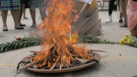 ritual religioso maya realizado con ofrenda de fuego sagrado rodeado de flores y otros elementos - cámara lenta