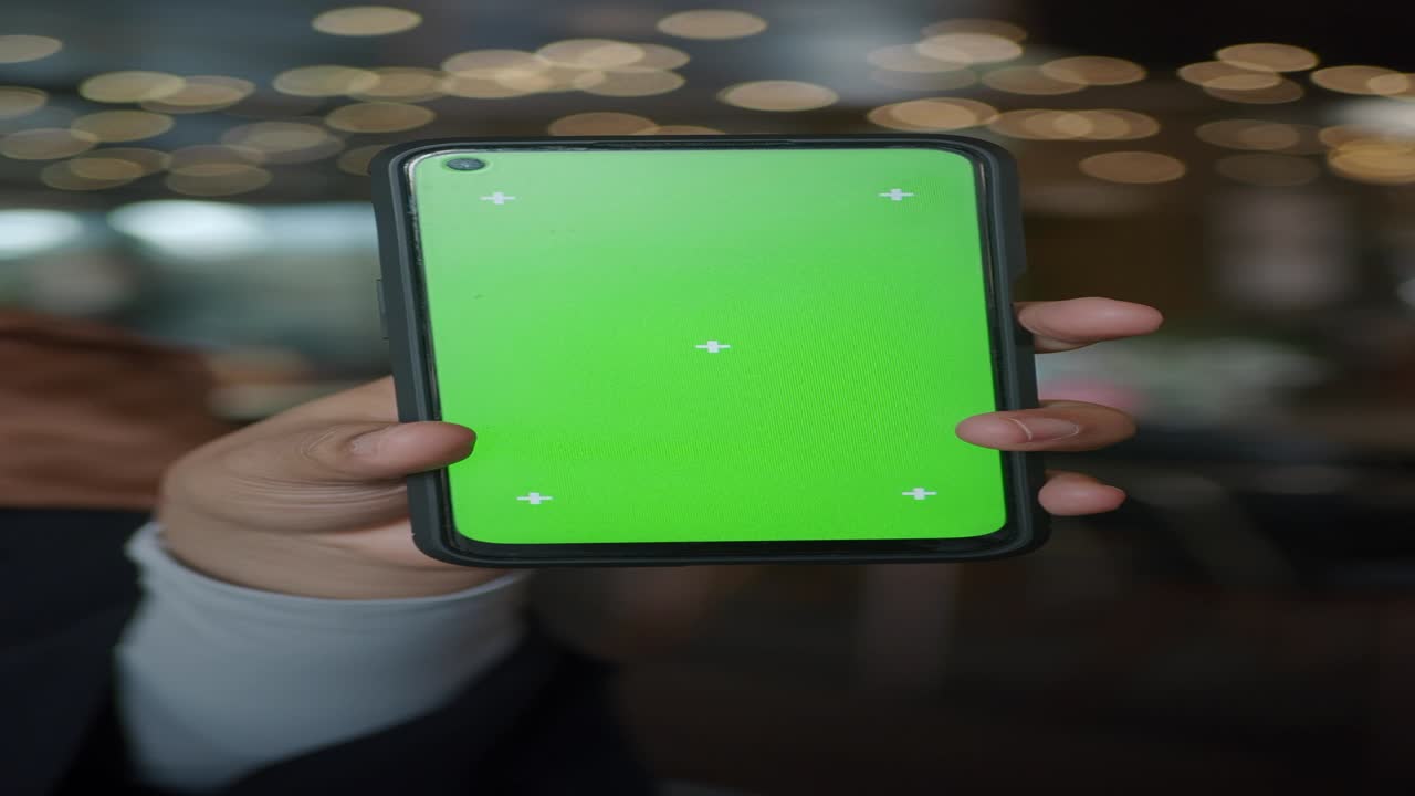 persona que sostiene un teléfono inteligente con una pantalla verde