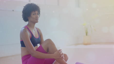 sitting on yoga mat, woman in sportswear with bokeh light animation