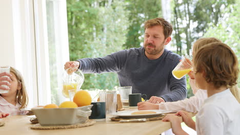 family wearing pyjamas sitting around table enjoying pancake breakfast together