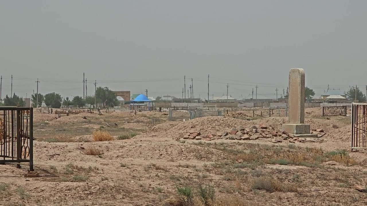 Vecchio cimitero in un paesaggio desertico con tombe tradizionali.