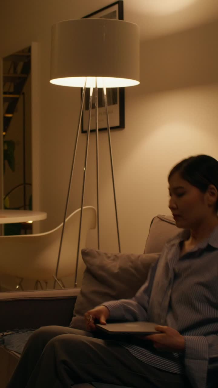 mujer trabajando en una computadora portátil en una acogedora sala de estar por la noche