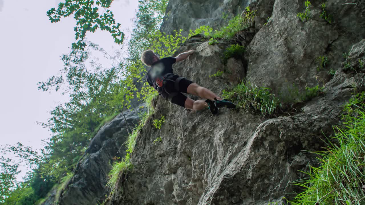 experienced pro rock climber moving up a vertical wall cliff. Adrenaline rush