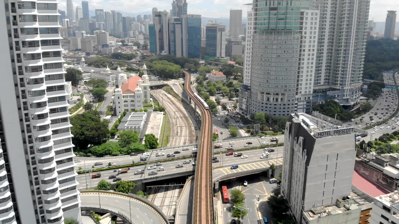 Aerial view of a moving Train tilting down. Tracking shot and tilting down. Kuala Lumpur, Malaysia.