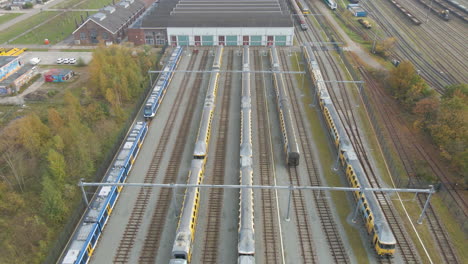 Aerial-of-trains-parked-in-front-of-workshop-at-train-yard