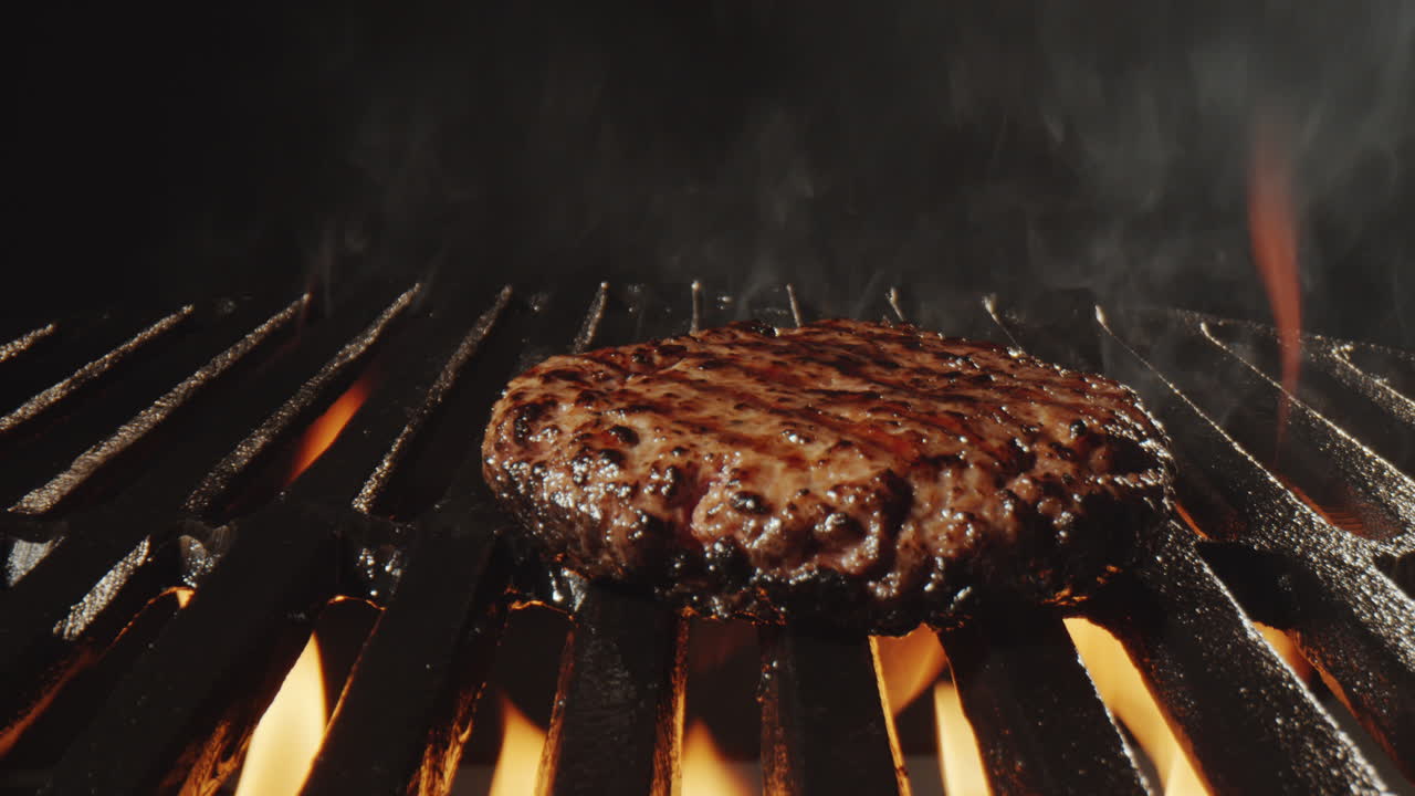 Cottura di carne per hamburger su griglia e fiamme